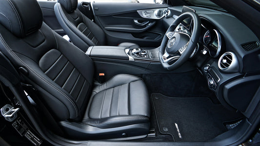 Luxury black leather car seats with white stitching inside a premium Mercedes interior, showcasing stylish car accessories.
