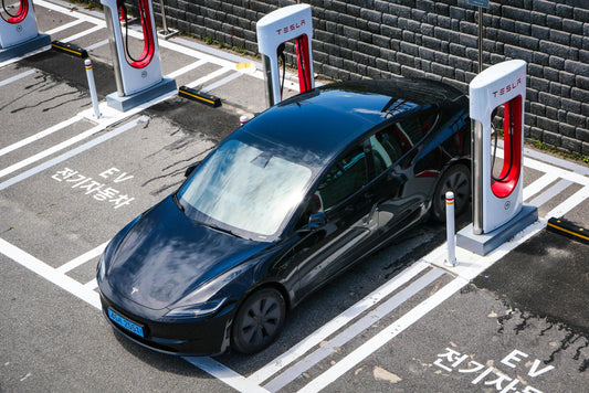 Tesla electric vehicle at fast charging station, representing growing EV adoption and infrastructure for modern drivers