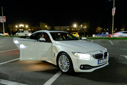 Properly aligned aftermarket headlights on a white BMW sedan at night, demonstrating clear road illumination